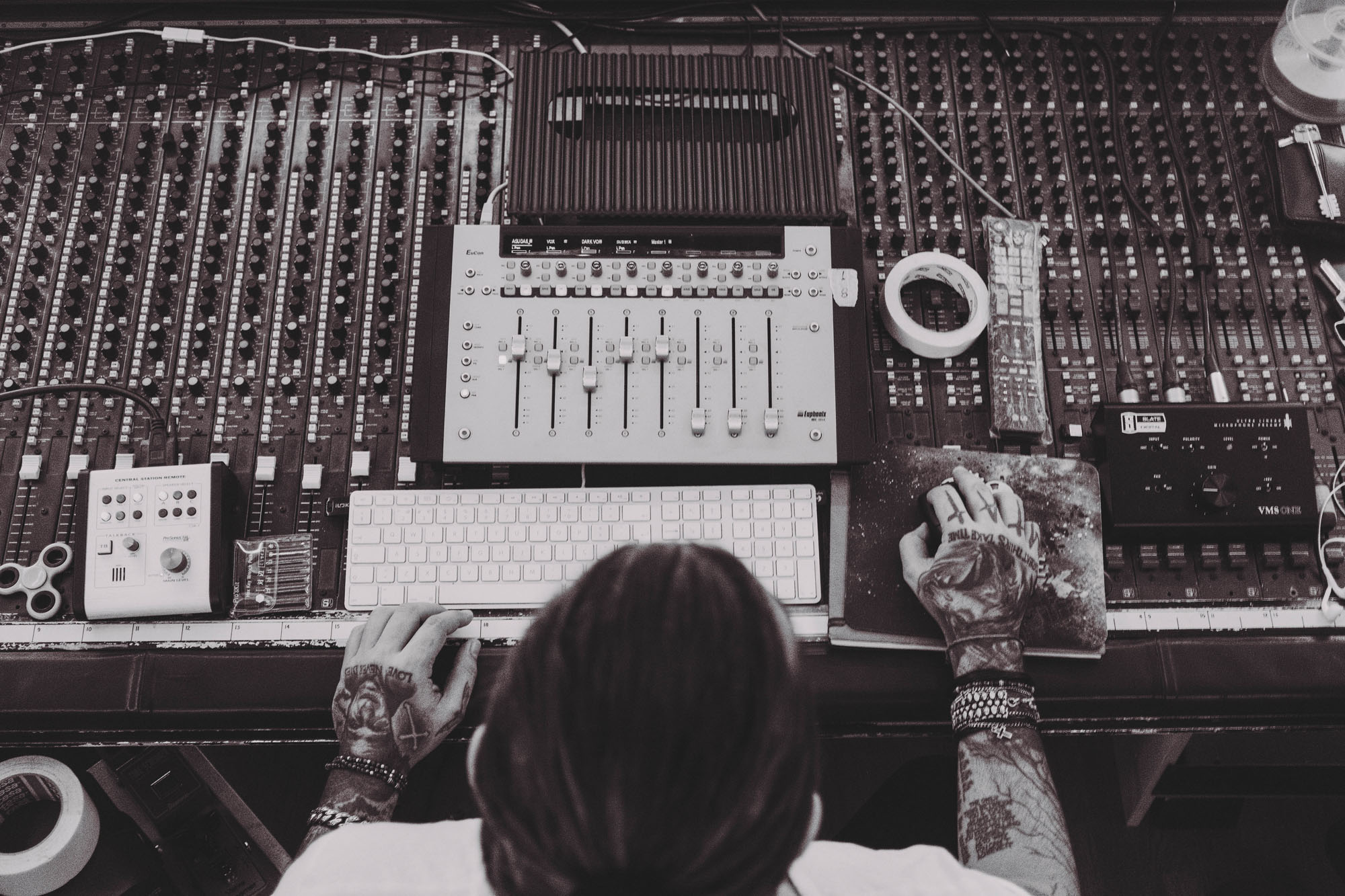 image of a sound engineer sitting on his mixing console.